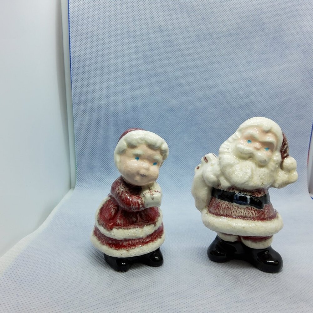 Vintage small ceramic Santa Claus holding sack and Ms. Claus holding presents